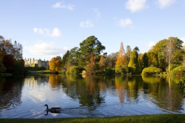 This photo shows one of the lakes in Sheffield Park with Sheffield Park House in the background