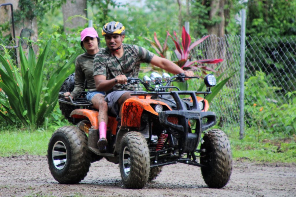 This photo shows a guy riding a quad bike with a girl riding pillion