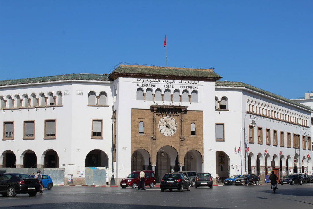This photo shows the pristine white Rabat post office building set against a vivid blue sky