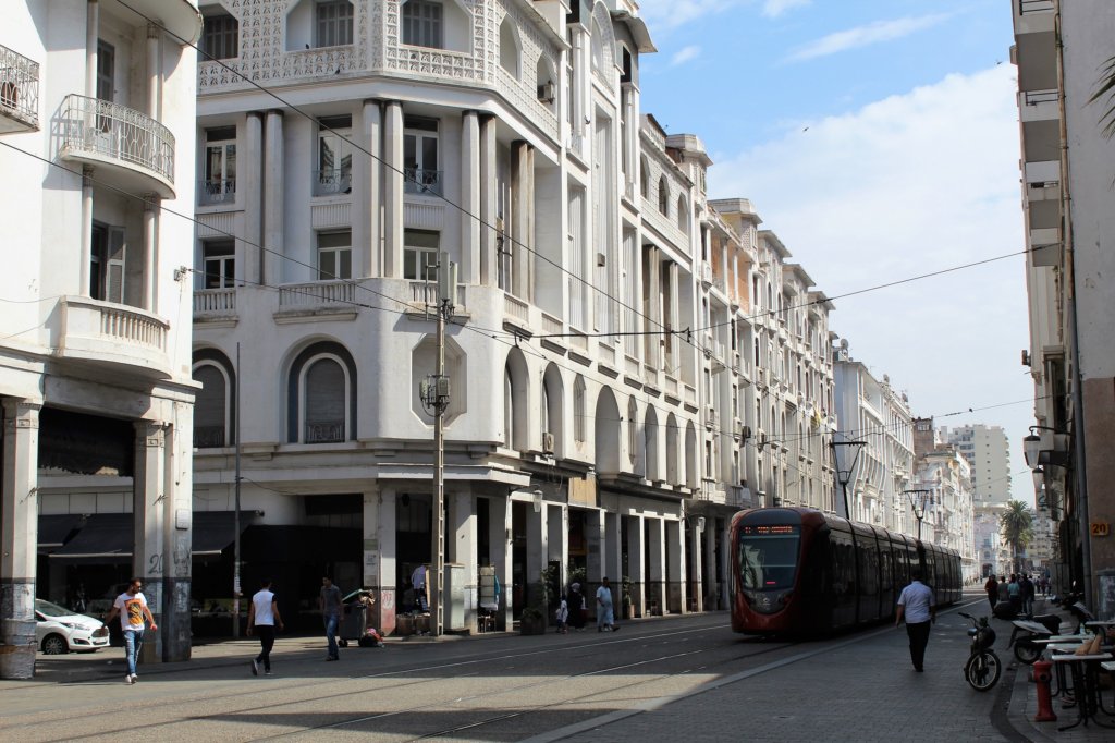 This photo shows a street in Casablanca with a tram running down the centre of it
