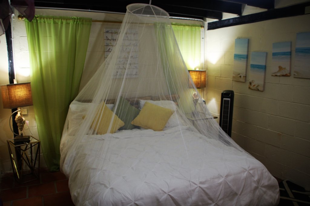 This photo shows the room we stayed in with crisp white linen and a mosquito net over the bed