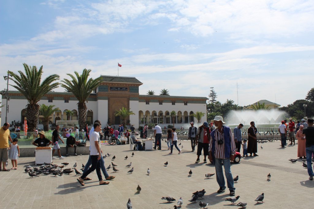 This photo shows people walking through Place Mohammed V - and lots of pigeons!