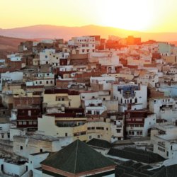 This photo shows the sun setting behind the hill beyond Moulay Idriss