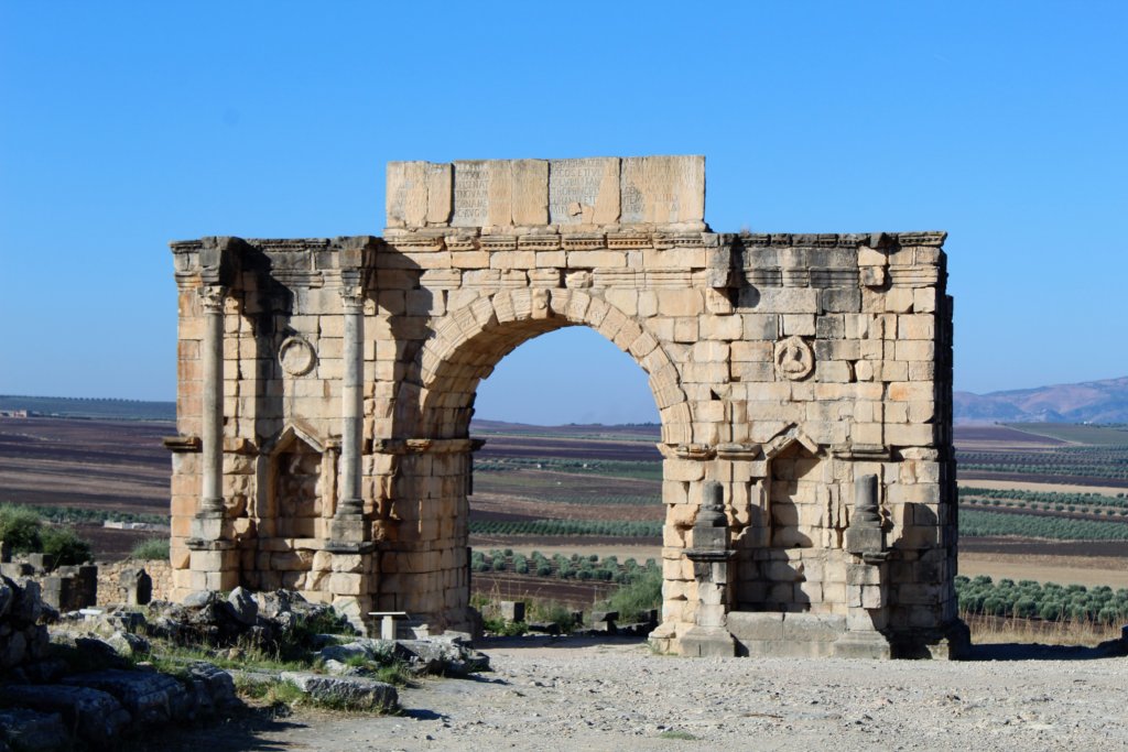 This photo shows the triumphal arch at Volubilis with the brilliant blue sky behind it.