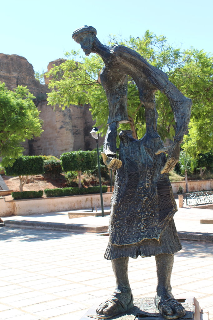 This photo shows a tall statue cast in bronze