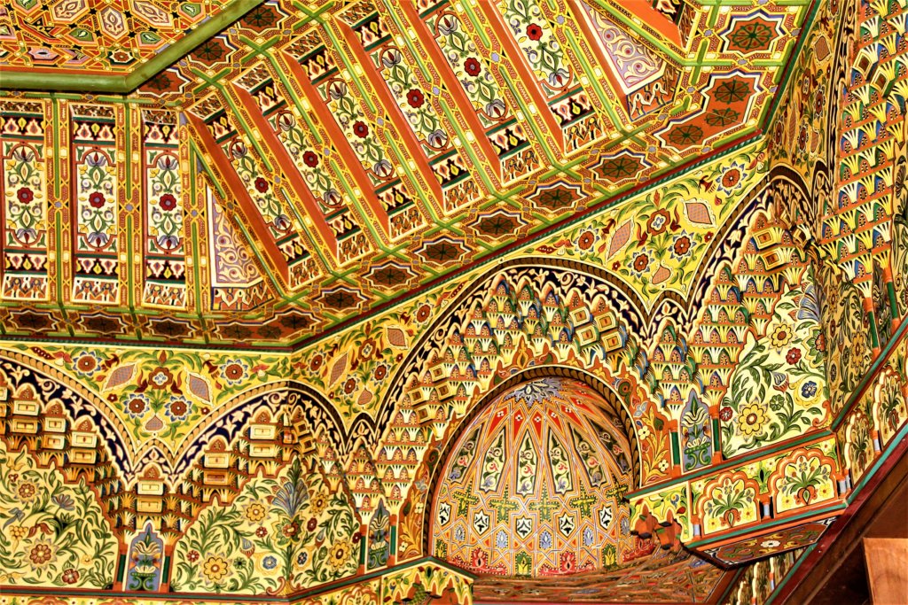 This photo shows a hghly decorative ceiling made of cedarwood and painted in gold, red and blue