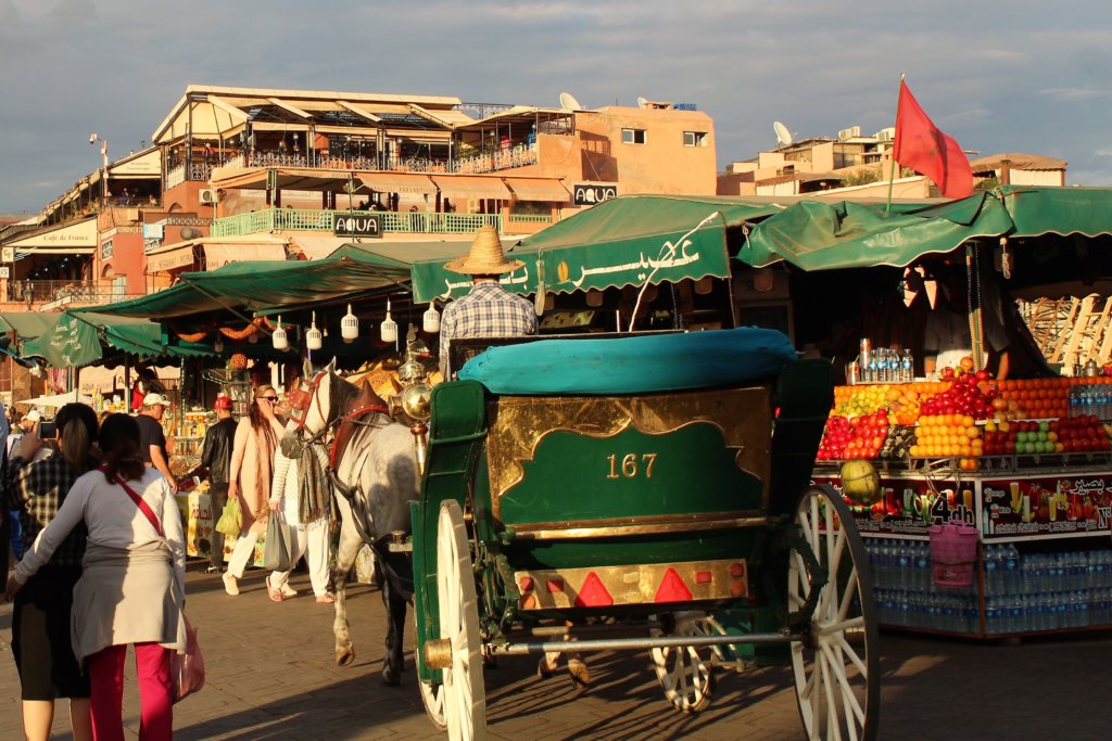 This photo shows a horse and carriage in front of colourful stalls at the starting point of our Tastes of Marrakech tour