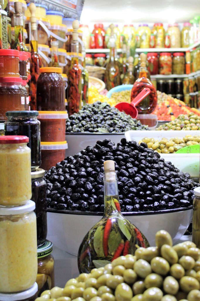 This photo shows an array of different olives carefully arranged for sale