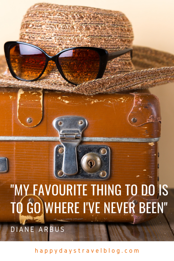 This photo shows an old suitcase with a sunhat and pair of sunglasses on top and the travel quote, 'My favourite thing to do is to go where I've never been.'