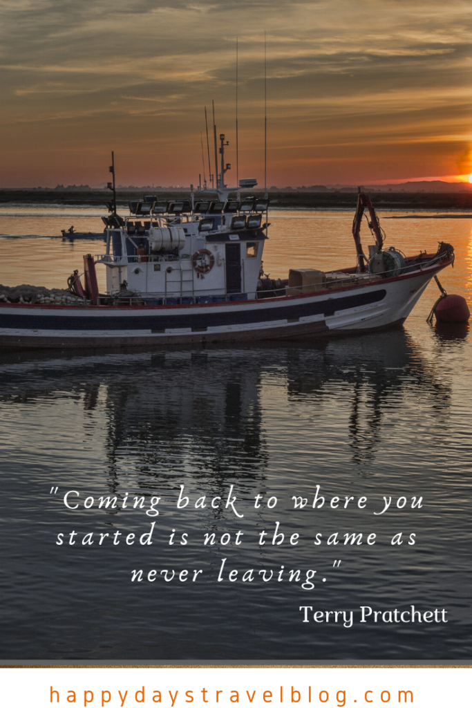 This photo shows a boat as the sun is going down and the quote by Terry Pratchett, 'Coming back to where you started is not the same as never leaving.'