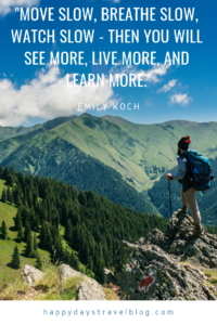 This photo shows a hiker on a mountain with the travel quote by Emily Koch, 'Move slow, breathe slow, watch slow - then you will see more, live more and learn more.' superimposed on top.