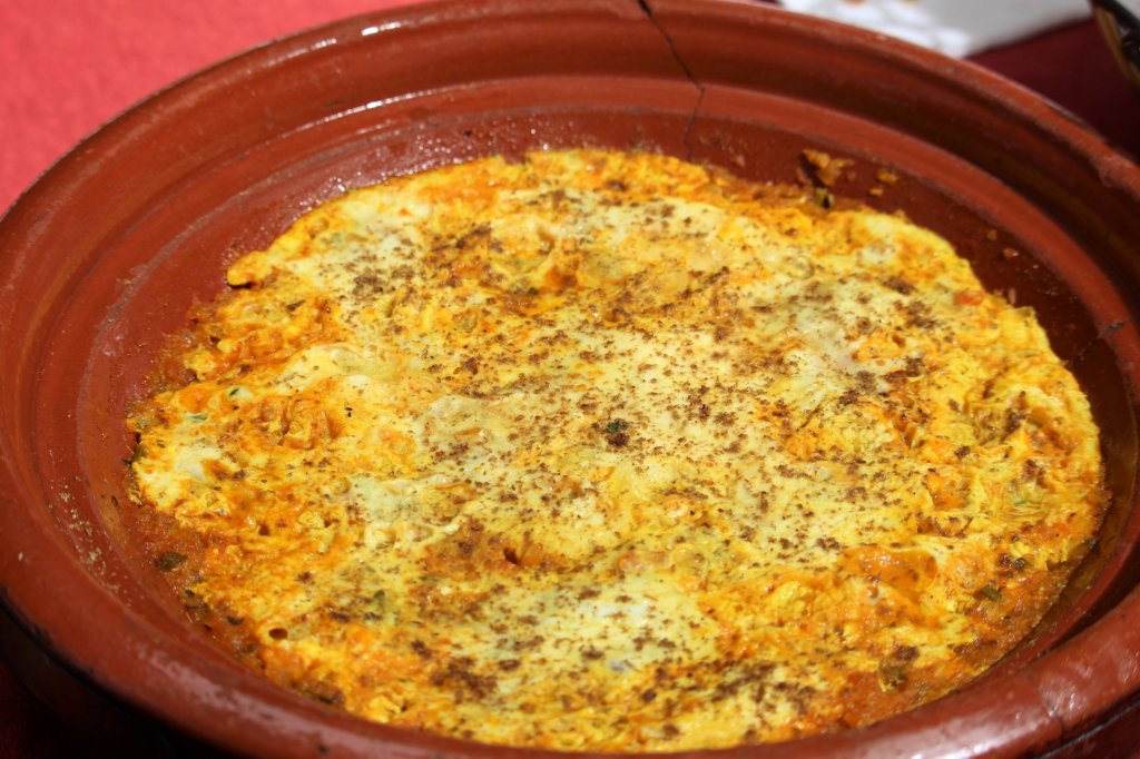 This photo shows cooked eggs in a terracotta ovenproof dish