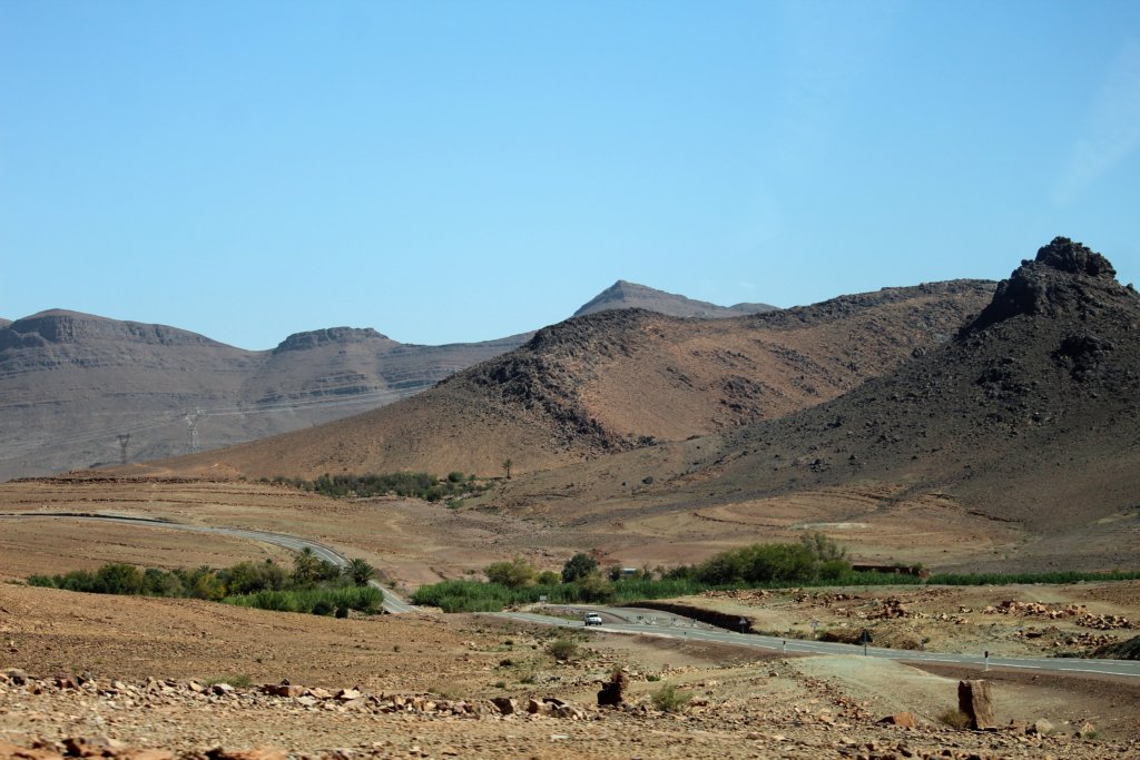 This photo shows a dry landscape in the Draa Valley with the mountains in the background