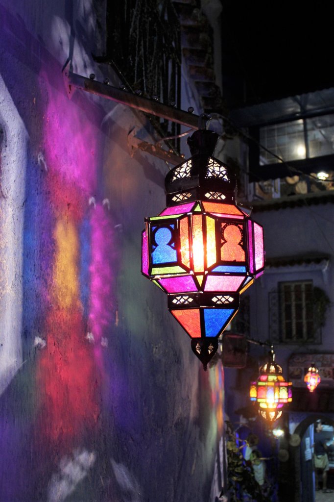 This photo shows colourful glass lamps outside the restaurant casting coloured shadows on the white wall