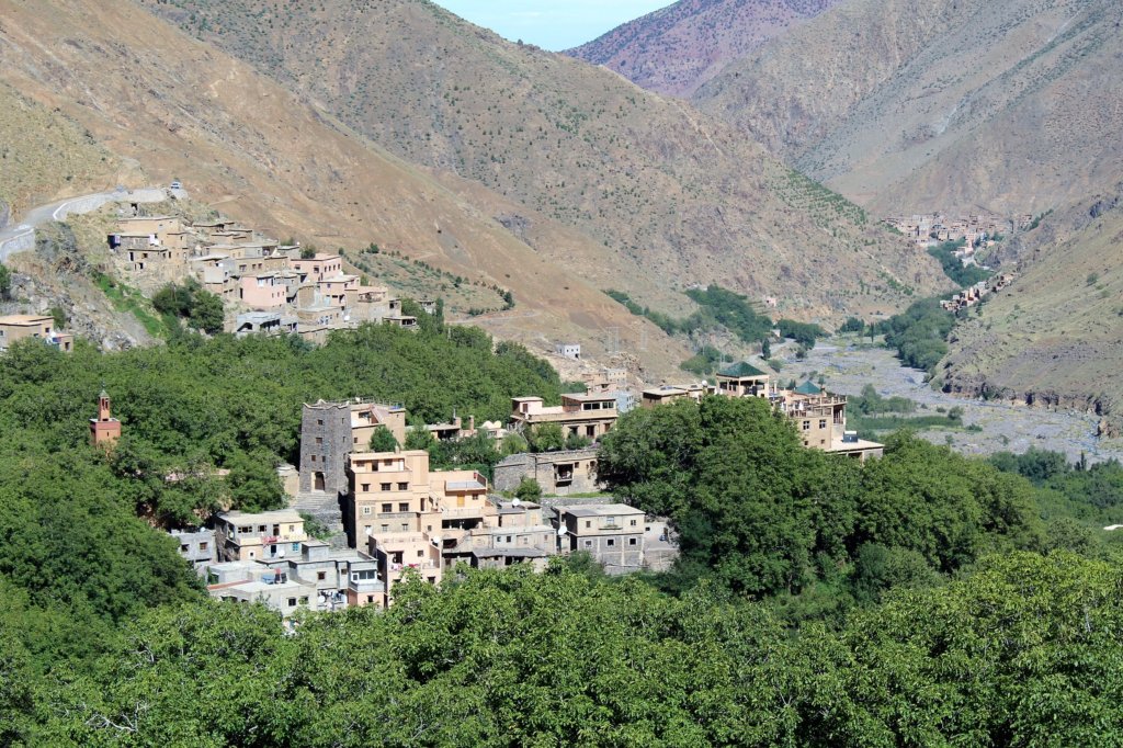 This photo shows a village with mountains behind