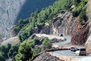 This photo shows a very windy road clinging to the side of a mountain