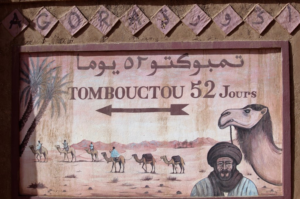 This photo shows a sign with an arrow pointing to the left and the caption, 'Tombouctou 52 Jours'