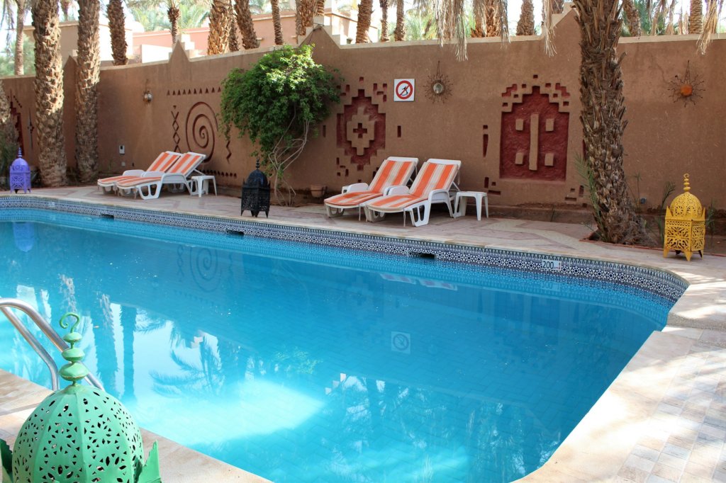 This photo shows the swimming pool at Chez Ali with loungers arranged around the edge