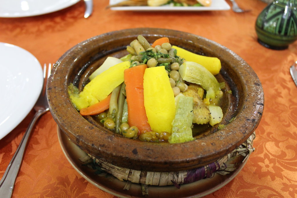 This photo shows vibrant yellow potatoes and carrots in a tagine
