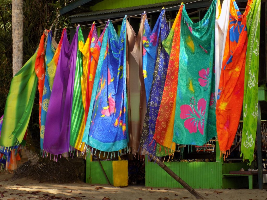 This photo shows a number of colourful sarongs hanging on a line