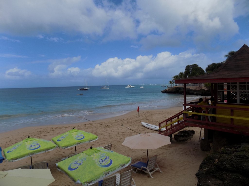 This photo shows the beach with parasols and the lifeguard's station