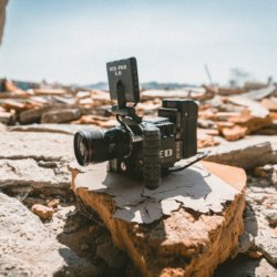 This photo shows a video camera sitting on some rocks.