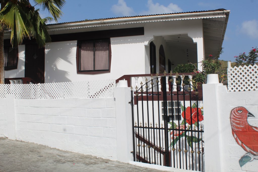 This photo shows the exterior of our Airbnb painted white with a decoration of a flower and a bird.