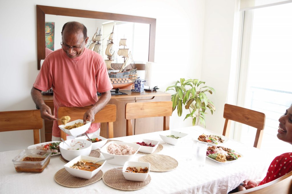 This photo shows the chef spooning curry from a dish to a plate