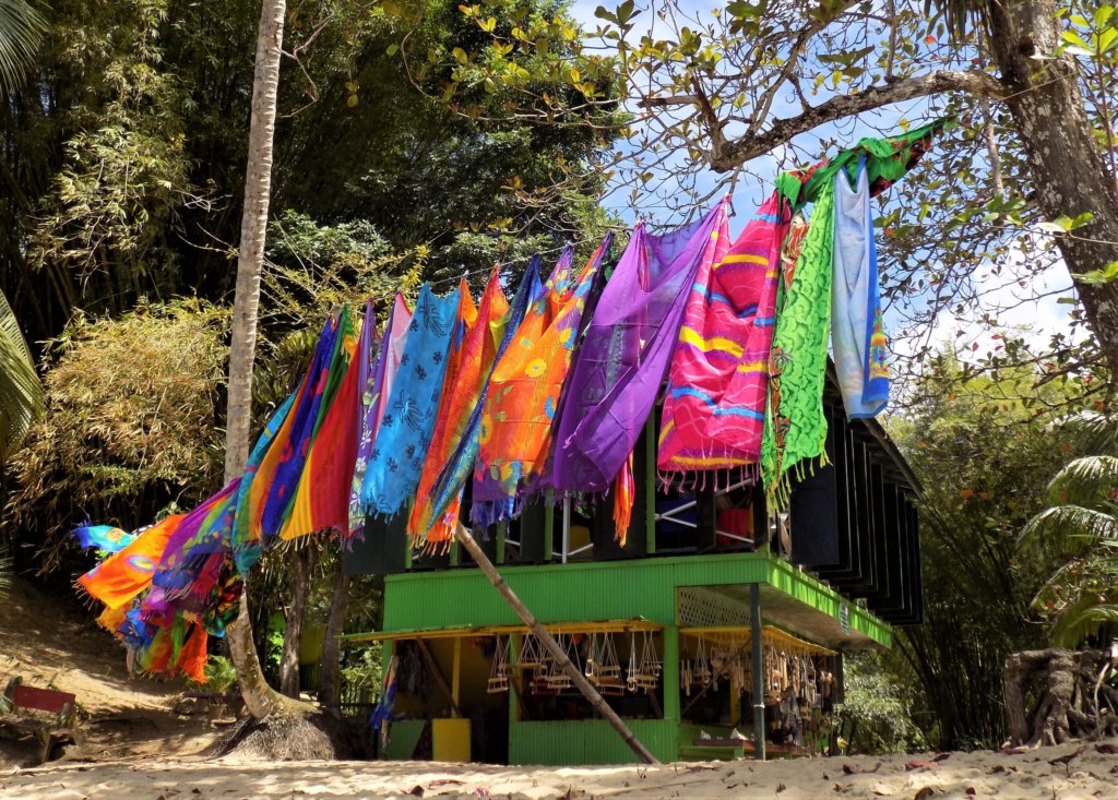 This photo shows Eula's Shack painted green with a washing line full of colourful sarongs blowing in front of it