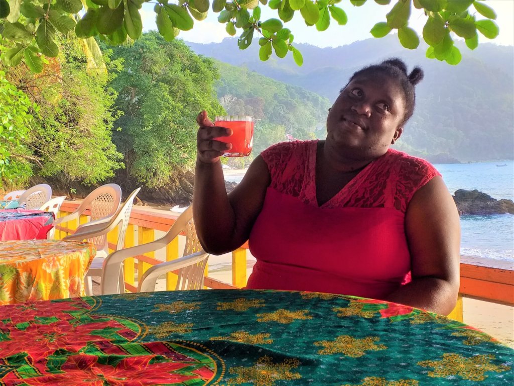 This photo shows Misha in a red dress holding a glass of rum punch