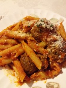 This photo shows a plate of meatballs with penne pasta