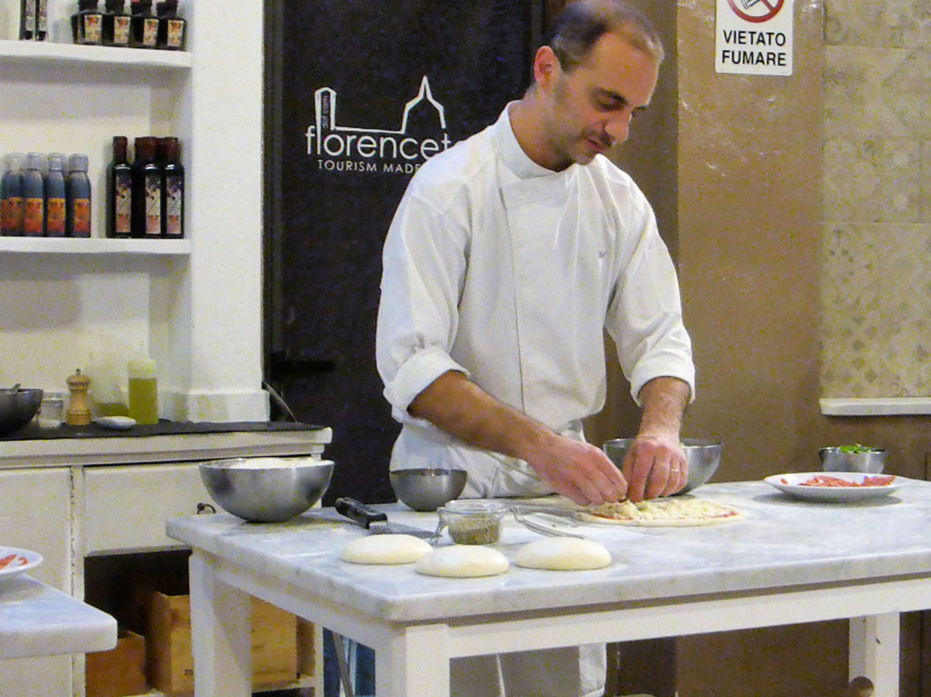 This photo shows a chef preparing pizza dough