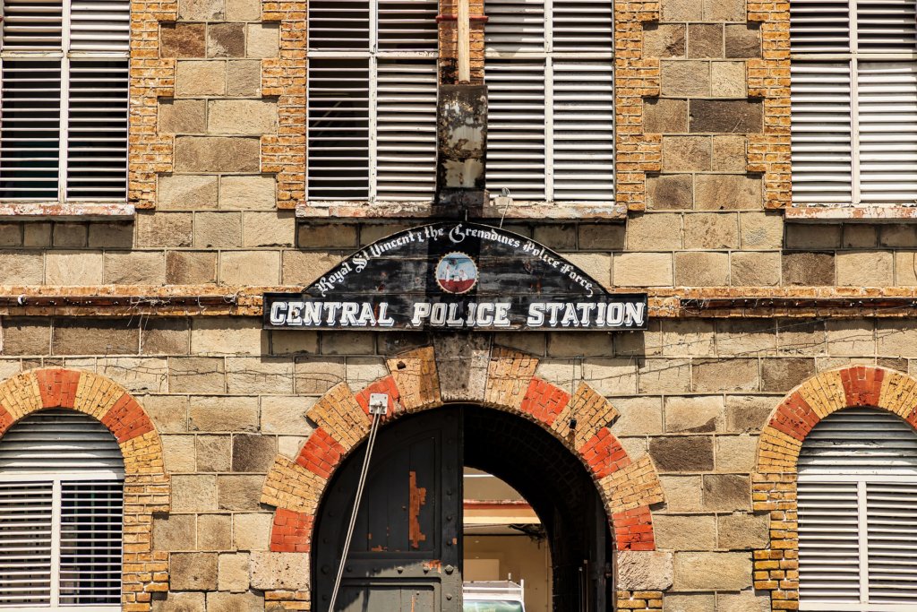 This photo shows the front of Kingstown police station built in red brick with an arch-shaped front door