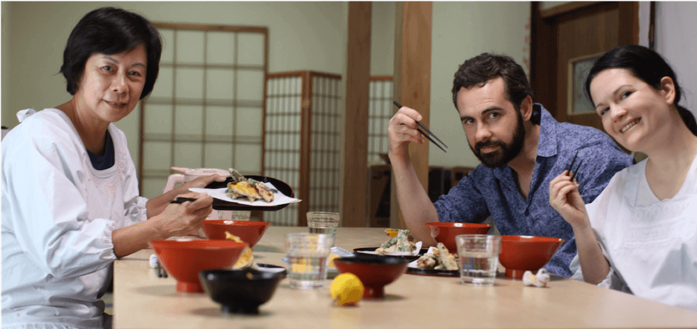 This photo shows a Japanese host and two western guests eating together