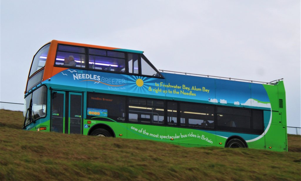 This photo shows a green and blue double-decker open-top bus