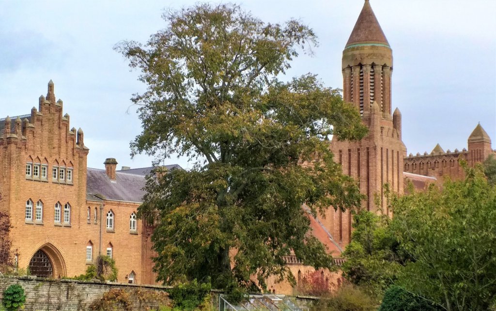 This photo shows a red-brick monastery with a tall belltower