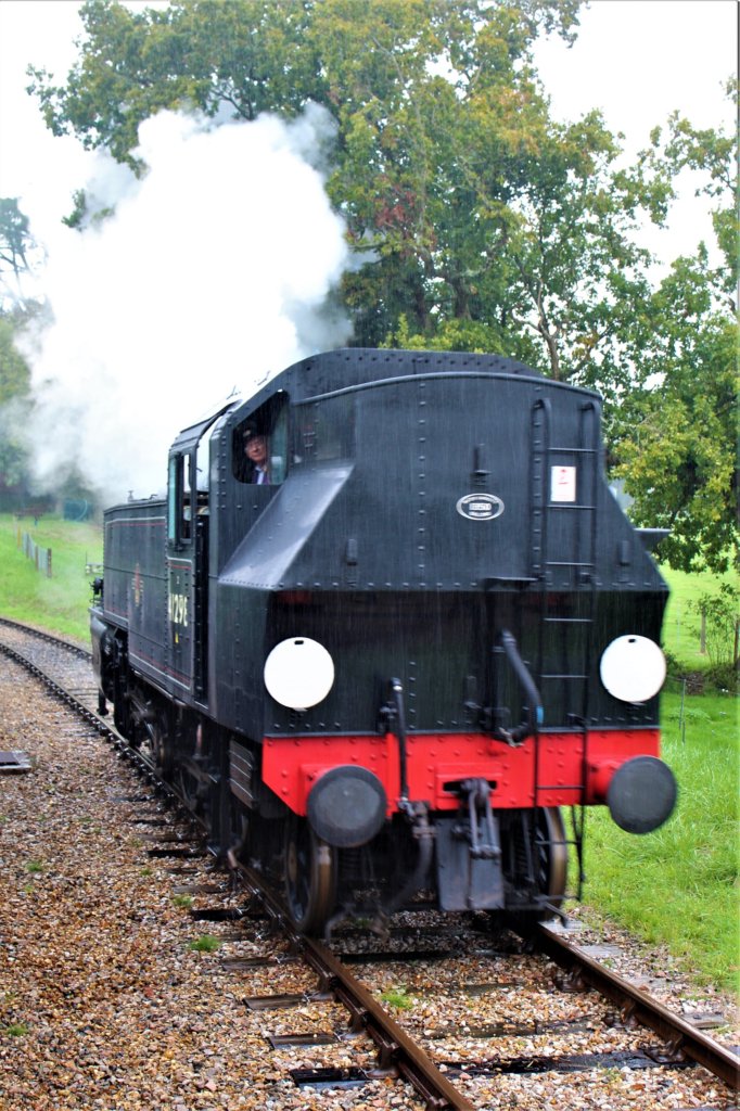 This photo shows a black steam engine with red trim