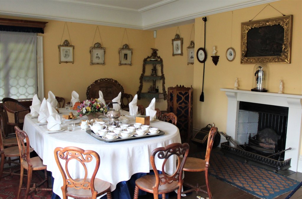 This photo shows an oval dining table laid for tea