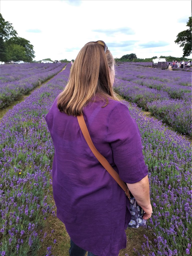 This photo is a back view of me wearing a purple shirt in a field of purple lavender