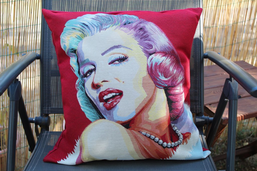 This photo shows a cushion with an image of Marilyn Monroe's head and shoulders on a red background.