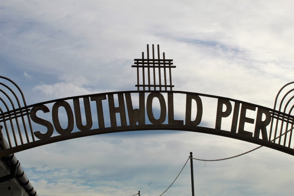 This photo shows a large metal arch with the words Southwold Pier marking the entrance to the pier itself