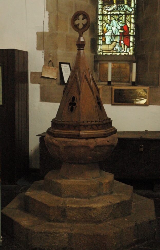 This photo shows the ancient font with its conical cover