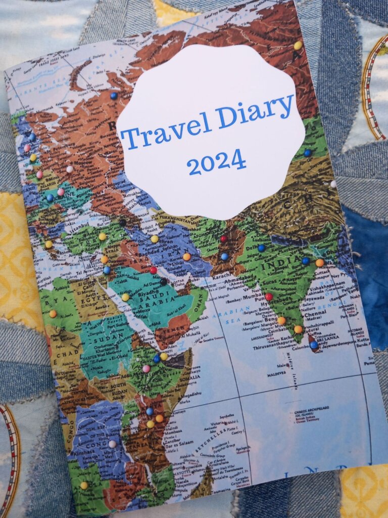 The front cover of the diary is a world map with pins to highlight locations.