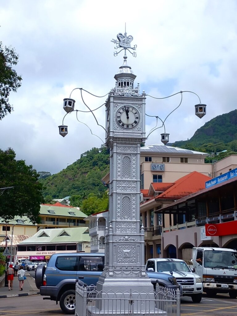 This photo shows a square clock tower painted in silver.