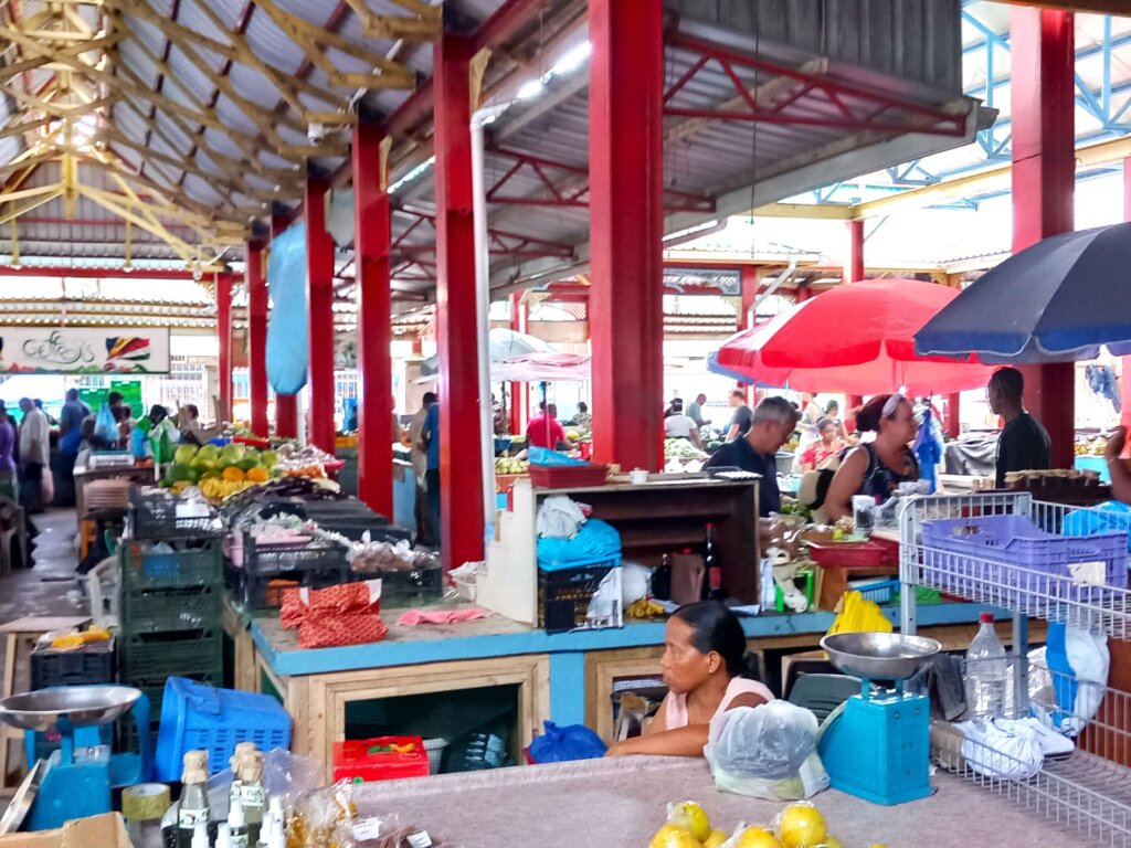This photo shows stalls and stallholders inside a market building.