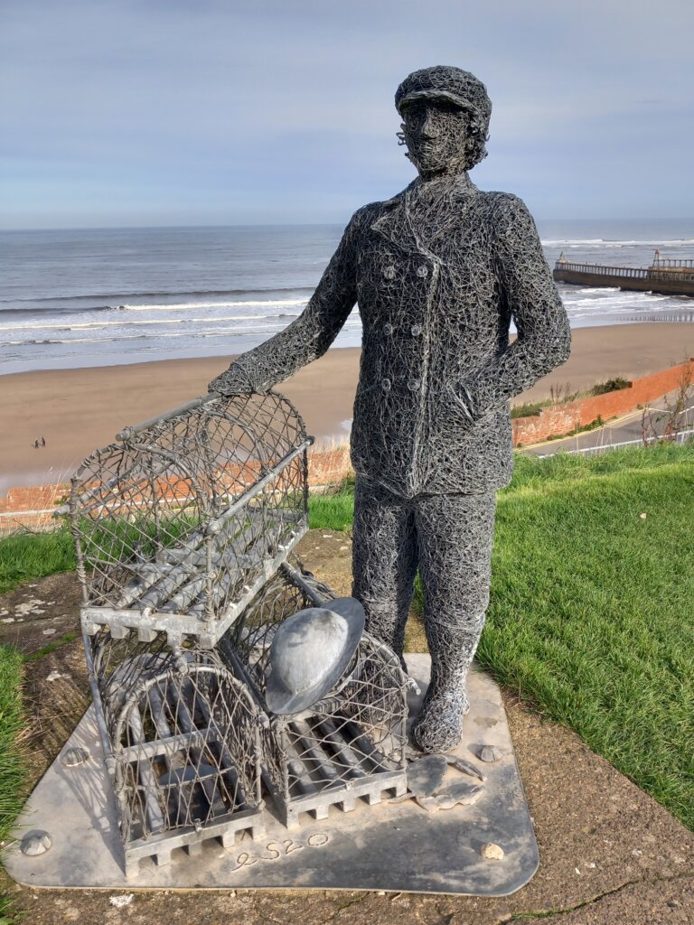 This image shows a sculpture of the first female captain of a Whitby fishing vessel.